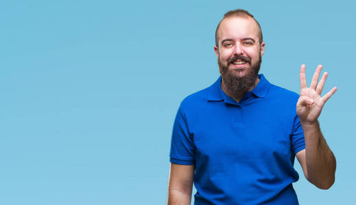 年轻的白种人臀部男子穿着蓝色衬衫，在孤立的背景上，显示和指着第四个手指，同时微笑自信和快乐。