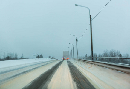 卡车在暮色中的一场雪灾中, 在雪飞来的时候, 带着尾巴和停车灯在冬天的路上行驶。在危险的条件下驾驶的概念, 冬季能见度差。Ima