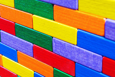 五颜六色的木头背景。 背景与五颜六色的形状木块。 彩色墙玩具彩色木砖。 多色木块。