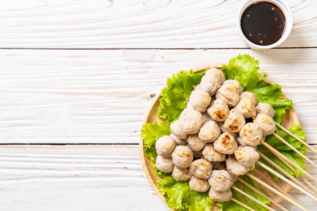 烤猪肉丸子,配甜辣酱烤肉丸子是街头美食的美味肉丸子烤在木篮盘上,桌