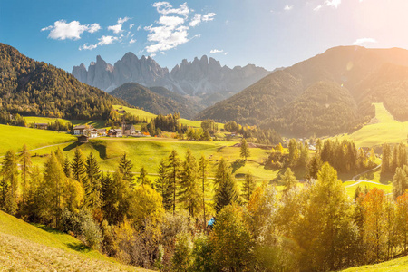 著名的旅游目的地在意大利白云石乐趣山谷。 瓦尔迪福内斯和圣玛格达莱纳村在秋天与岩石阿尔卑斯山的背景。