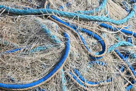在港口用五颜六色的生动浮子和缆绳封闭成堆的海钓网的背景