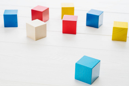 白色木制背景上的木制玩具立方体。 五颜六色的木制积木。
