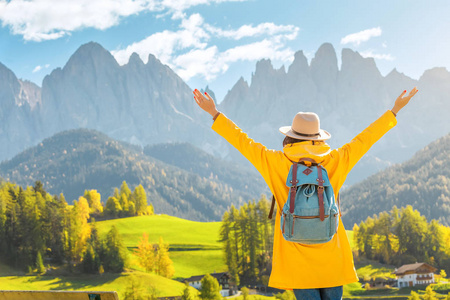 快乐的年轻女子在秋天的意大利白云石山旅行