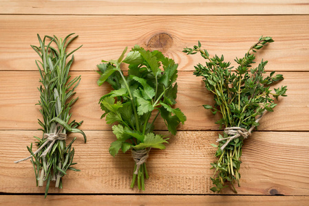 一束迷迭香香菜和百里香有机植物，用于健康食品。 木制背景