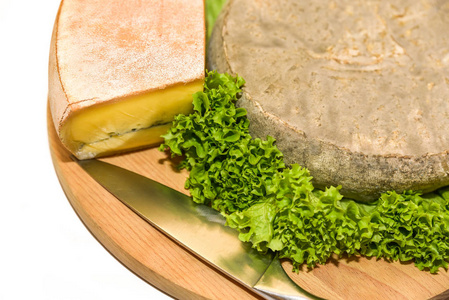 柔软的奶酪，莫比尔和圣蜜桃，来自法国，沙拉部分在木盘上。 肤浅的焦点。
