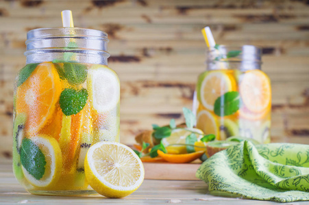 木制桌子上的排毒水果水. 新鲜自制柠檬水和薄荷.