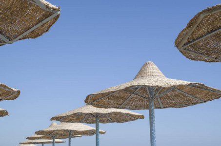 许多海滩伞从柳条在天空中，埃及
