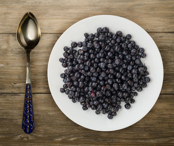 在木制背景上的盘子上的蓝莓。 水果饮食。 素食食品。