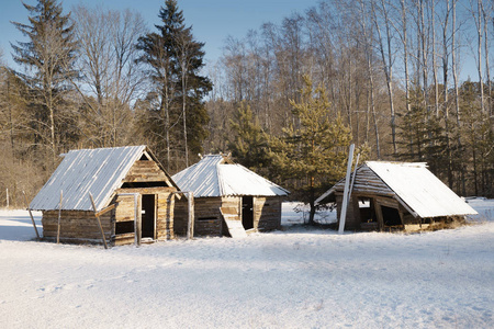 在森林边缘的雪林中的木路，阳光明媚的冬日，白雪覆盖的屋顶，冬天的森林