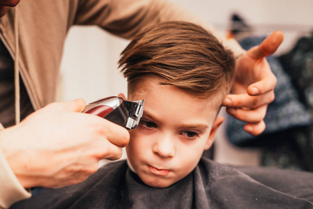 理发店理发小男孩剪发的剪影照片