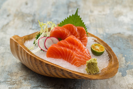 三文鱼刺身加冰在陶瓷盘子里照片