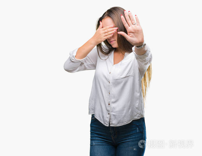 年轻的高加索美女戴着眼镜在孤立的背景上用手遮住眼睛用悲伤和恐惧的