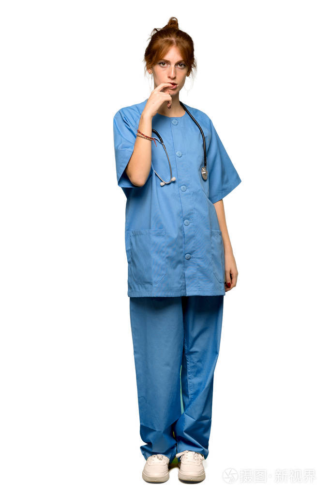 一个年轻的红发护士在看着孤立的白色背景时有疑问的完整镜头