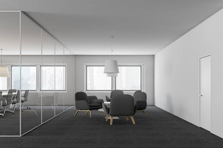办公室休息室内部有白色墙壁地毯地板灰色扶手椅,靠近圆形咖啡桌和