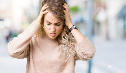美丽的年轻金发女人穿着毛衣，穿着汗衫，在孤立的背景上，手在头上疼痛，因为压力。 偏头痛。