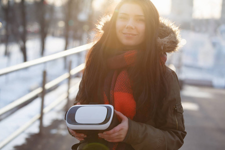 年轻女性带着新的虚拟现实眼镜走到户外，用于移动游戏应用程序。使用移动游戏应用程序。现代增强现实游戏玩家小工具。带创新小工具的漂亮
