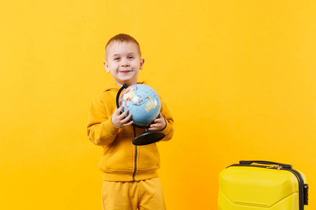 小旅行者旅游孩子男孩34岁孤立在黄色橙色墙背景工作室。 周末出国旅行的乘客下车。 航空飞行旅程概念。 模拟复制空间