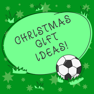 显示圣诞礼物创意的书写笔记。商业照片展示建议最好的礼物给在圣诞节足球球在草和空白概述圆颜色形状的照片