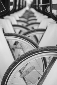 自行车停放在自行车停车场的车轮。租赁自行车皮卡站。接近浅层的田野。清洁和安全的生态城市交通