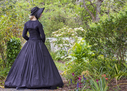 维多利亚时代的女子在花园里的黑色合奏