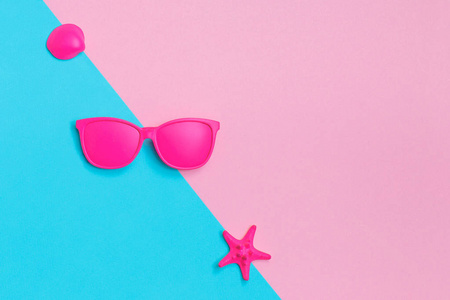 五颜六色的背景上的粉红色眼镜和贝壳。最小的概念。创意理念。炎热的夏天 vibes。流行艺术。明亮甜美的时尚风格