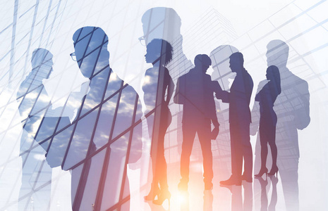 多人剪影管理人员和他们多样化团队成员在摩天大楼背景下的剪影.