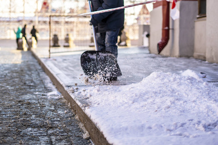 成年男子铲雪从城市街道