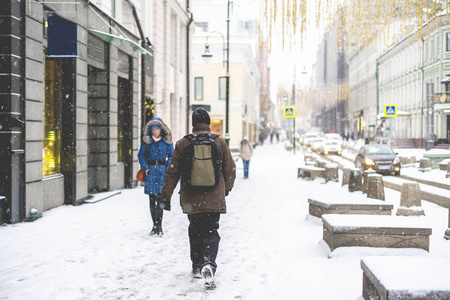 人们在雪下走在城市街道上