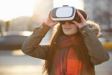 年轻女子在虚拟现实眼镜中玩手机游戏应用程序。