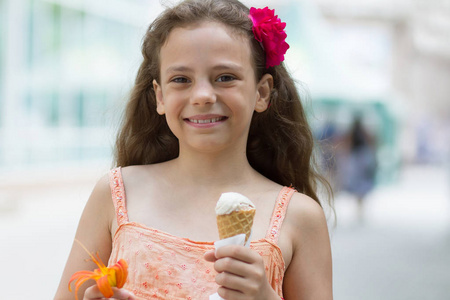 可爱的小女孩手里拿着冰淇淋和百合花