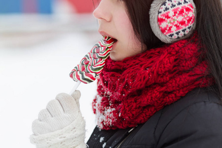 冬天在户外吃棒棒糖的青少年女孩