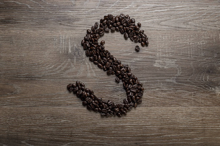 黑烤咖啡豆排列在木桌上，呈文字字母S形