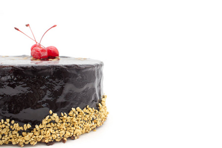 美味的巧克力蛋糕装饰樱桃和脆果仁，一个孤立的白色背景。 带有复制空间区域的蛋糕。