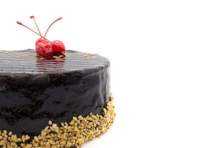 美味的巧克力蛋糕装饰樱桃和脆果仁，一个孤立的白色背景。 带有复制空间区域的蛋糕。
