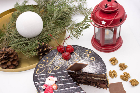 美味的巧克力蛋糕装饰樱桃和糖圣塔和脆果仁与圣诞节装饰和装饰。