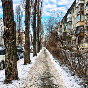 冬天的城市街道。冬天的老式城市景观。停车，雪，蓝天和云彩