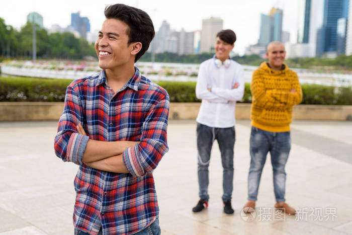 三名年轻的亚洲男子一起在公园里放松