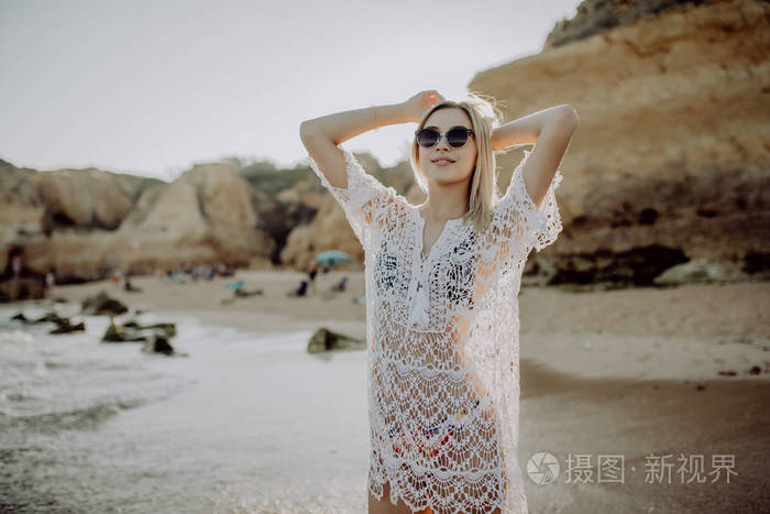 海滩度假. 穿比基尼的漂亮女人在海滩上散步,享受完美的晴天. 幸福和