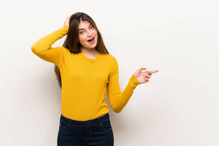 一位年轻女士,穿着黄色毛衣,手指指向侧面,展示了一种产品照片