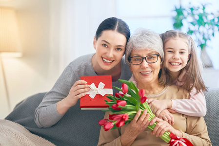 s day Child daughter is congratulating mom and granny giving th