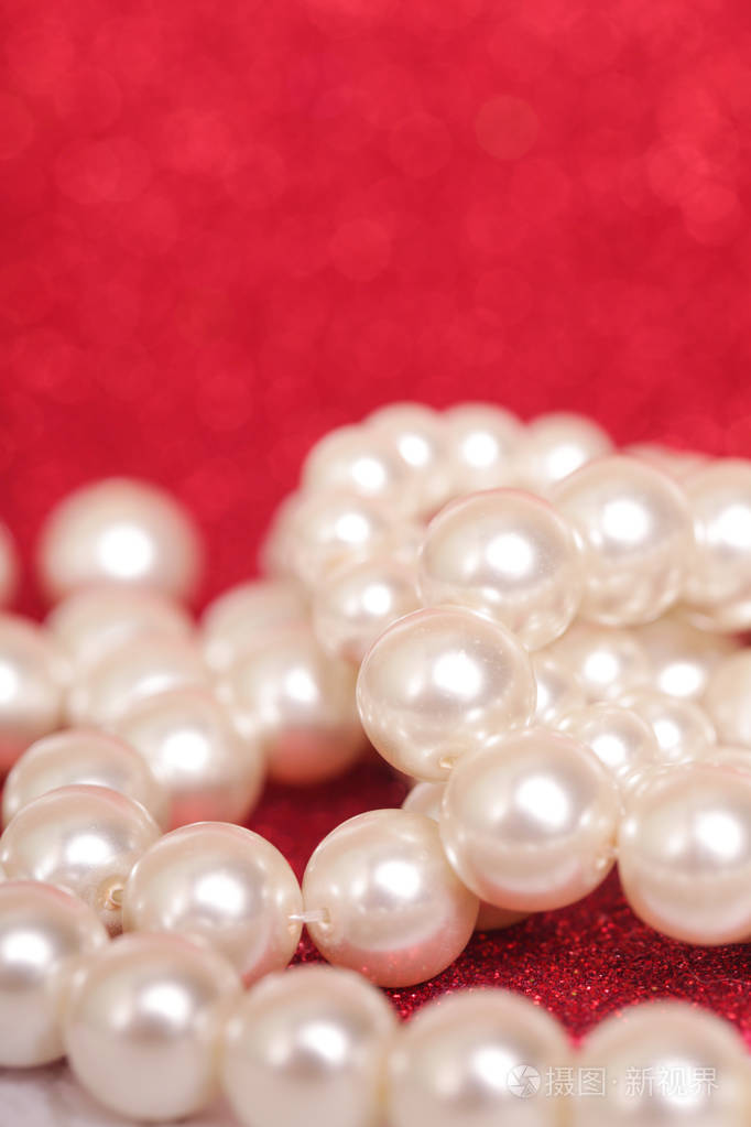 一堆珍珠在红色上红色圣诞背景上的一堆珍珠