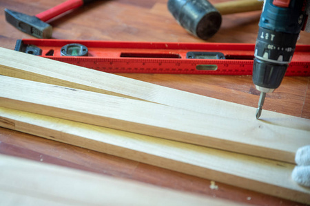 用钻床建造DIY。 专业木匠在房子里用木材和建筑工具进行翻新。