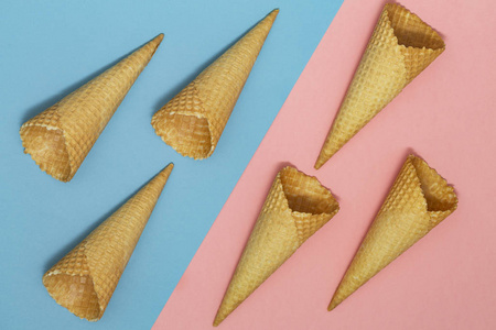 冰淇淋华夫饼锥在粉蓝色背景上。 华夫饼冰淇淋锥。 上面的风景。 平躺着。 现代最小成分