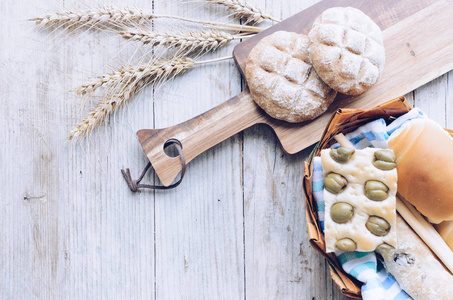 各种传统的意大利新鲜烘焙的硬面包和面包，耳朵在木桌背景上。 带橄榄的Focaccia。 乡村复古风格。 上面的风景。 复制空间。