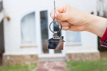 房地产和财产概念手是拿房子钥匙房子形状钥匙串在一个新的家前面