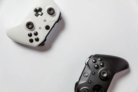 白色和黑色两个操纵杆游戏垫游戏机隔离在白色背景。 计算机游戏技术游戏竞争视频游戏控制对抗的概念。 网络符号