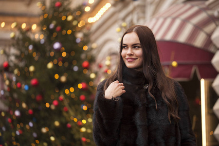 莫斯科市中心的冬红广场上，一位身穿貂皮大衣深褐色头发的年轻女子的肖像