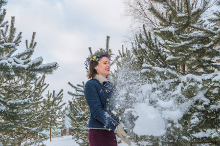 美丽的姑娘白雪皑皑的冬天站在圣诞树上，头上戴着花环