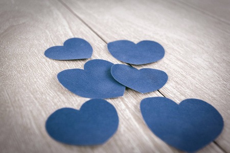 三对蓝色的心在一个轻的木制背景